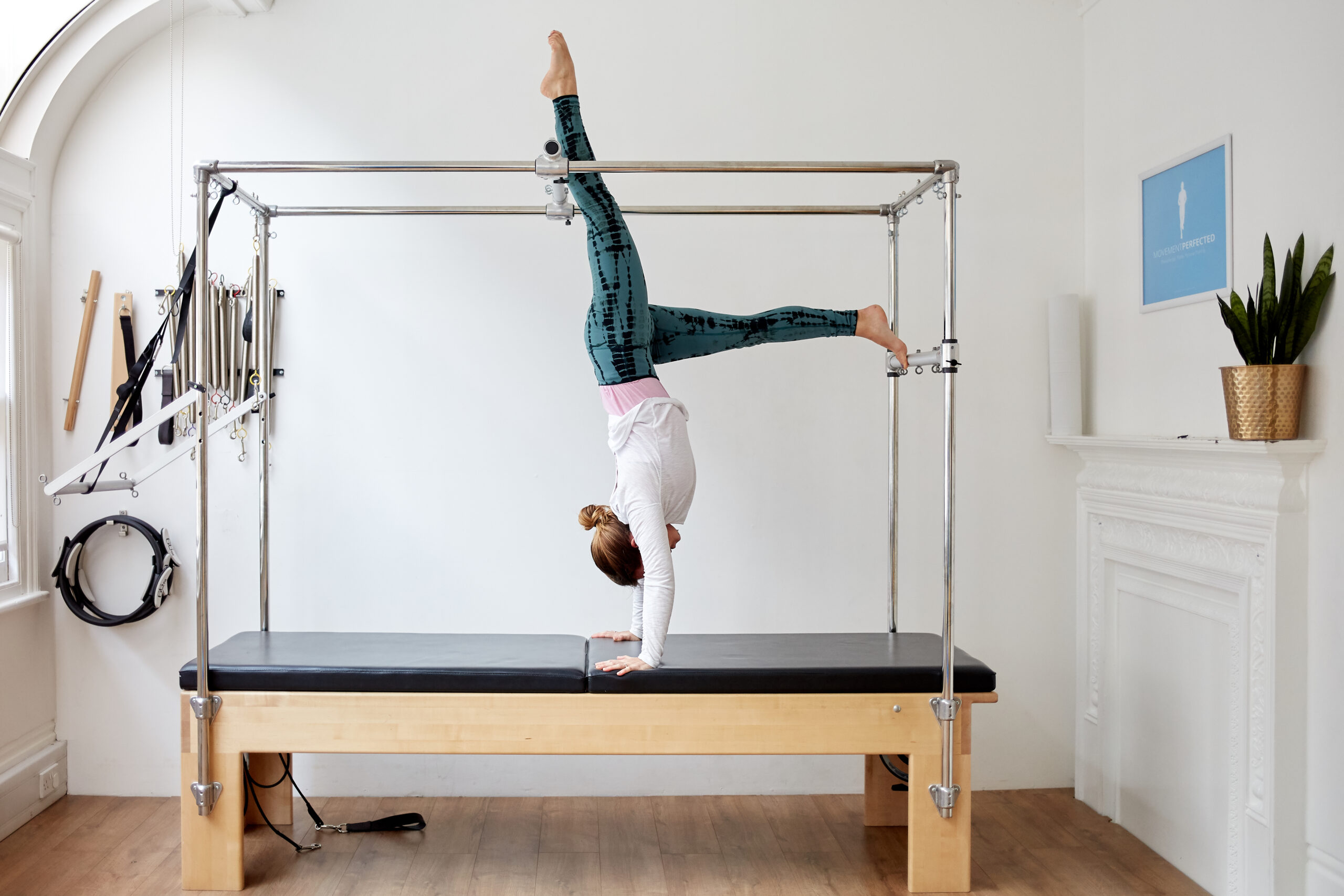 Physiotherapist Megan demonstrating a handstand on the Trapeze Table at Movement Perfected Moorgate